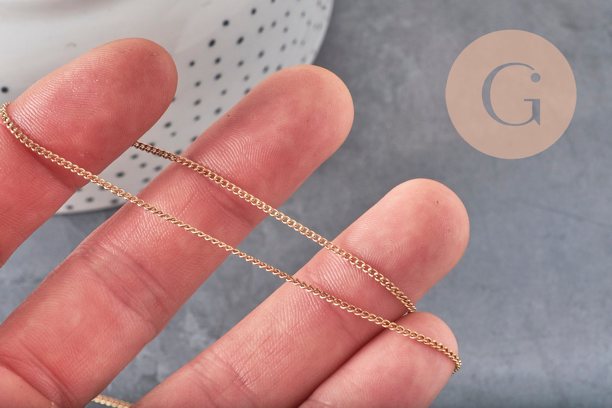 Chaîne plate fine en laiton brut de 1,5 mm tenue entre les doigts pour la création de bijoux DIY.