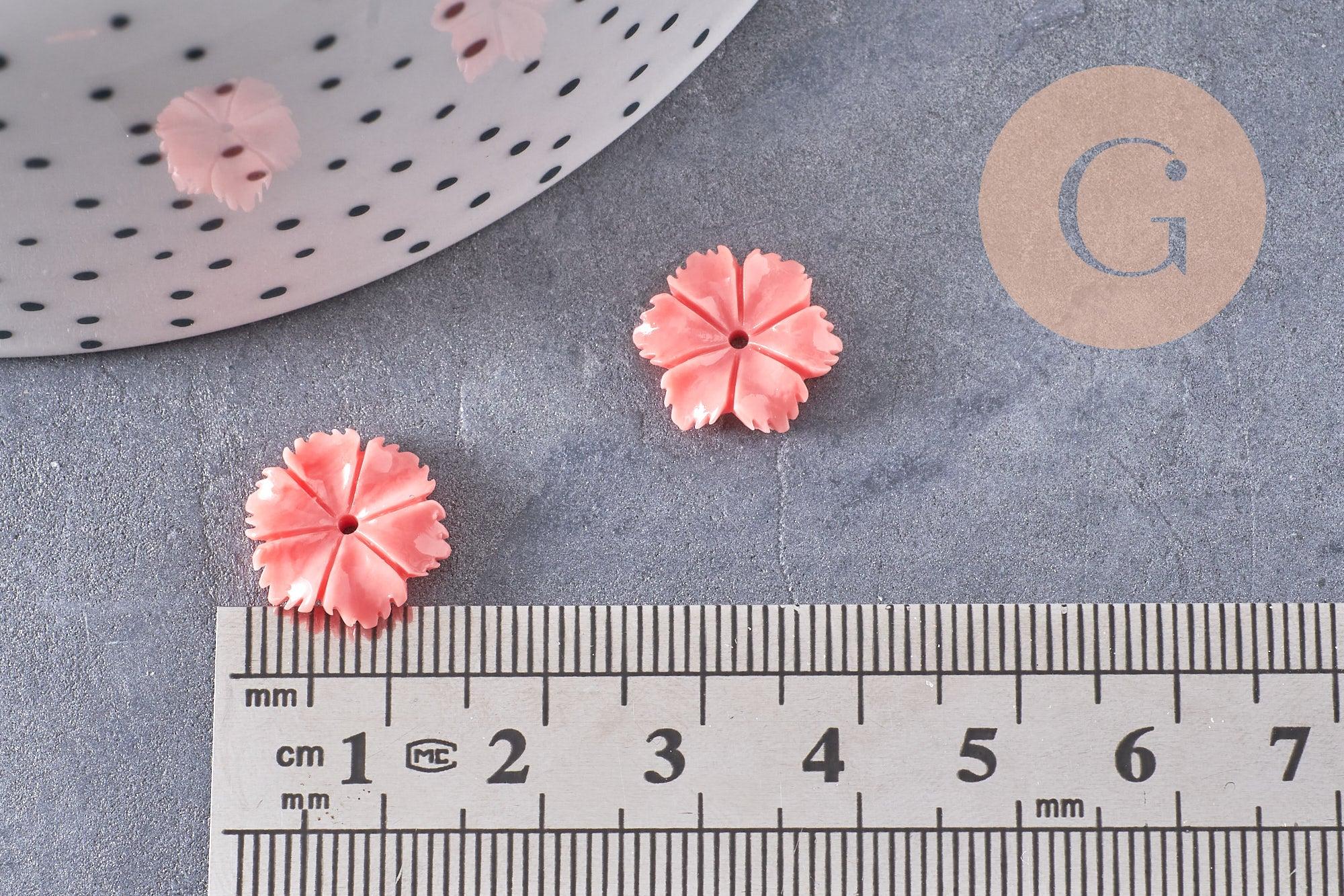EP-Perle fleur résine rose: Five coral pink flower-shaped beads beside a ruler, ideal for jewelry making. Each bead measures 13mm with a 1mm hole.