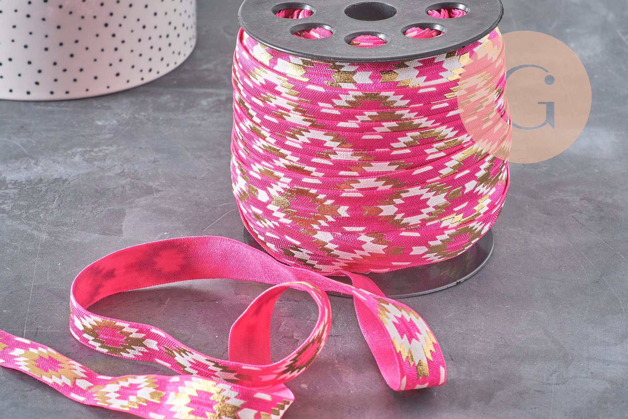 Bobine de ruban élastique rose de 16mm avec motif aztèque géométrique doré pour bijoux DIY bohème chic.