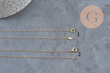 Collier chaîne fine dorée gold-filled 45.7cm avec fermoir, vue de dessus sur fond gris.