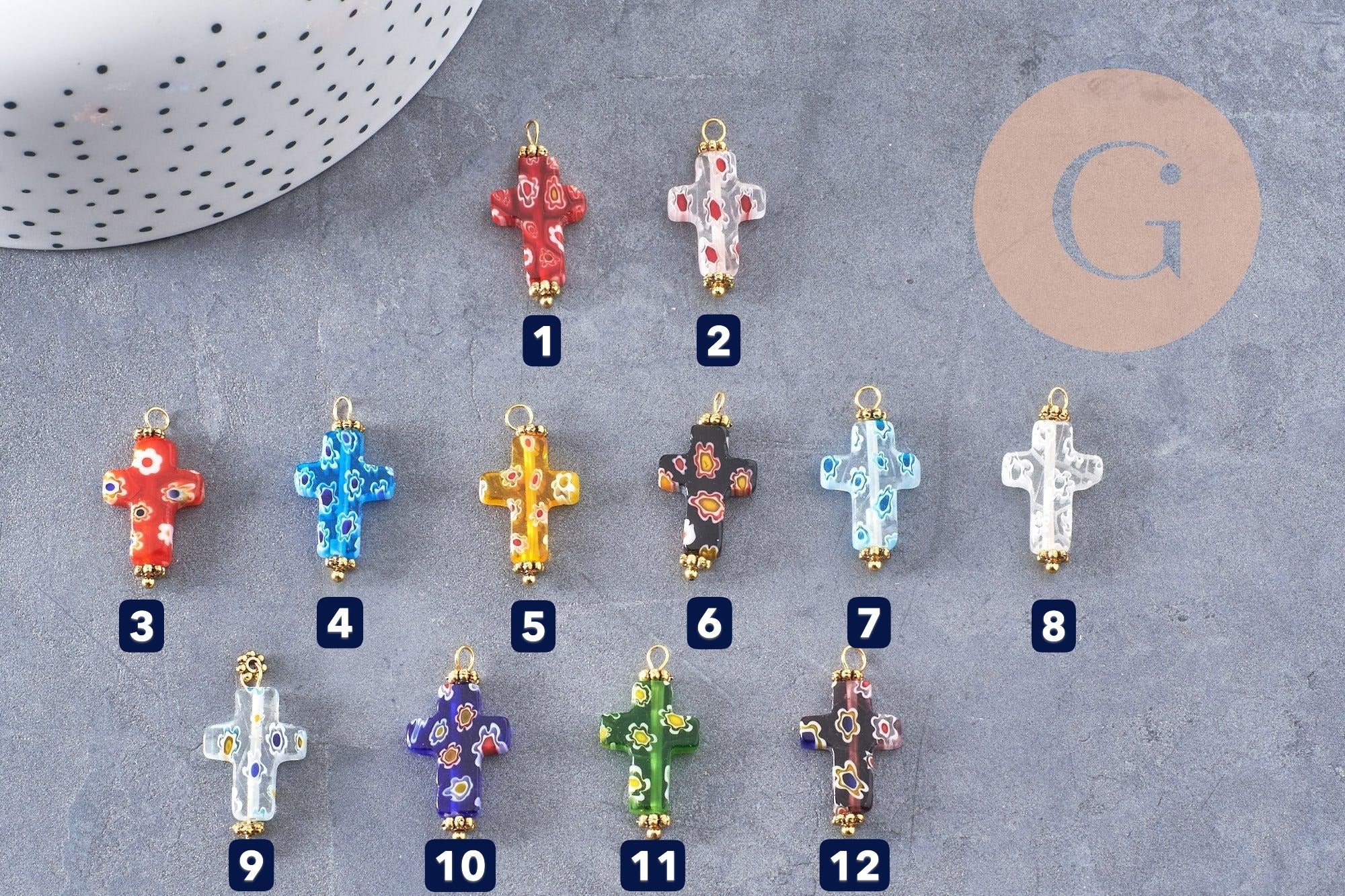 Glass millefiori cross pendant with gold-toned brass and zamac accents, 24.5mm, displayed in multiple colorful patterns on gray surface