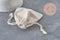 Pochette bijou 12cm en coton blanc écru avec cordon de serrage, idéale pour emballer des bijoux artisanaux.